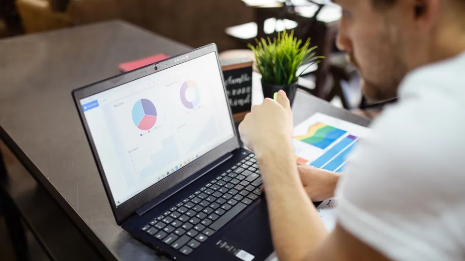 Dirigeant de TPE lisant un rapport d'audit de site web sur son ordinateur portable