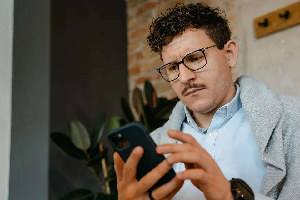 Artisan consultant son téléphone pour prendre contact avec un prestataire web